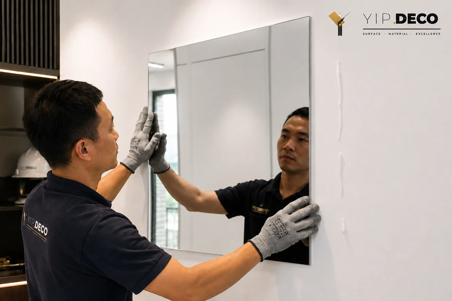 Installer bonding a lightweight acrylic mirror panel to a wall